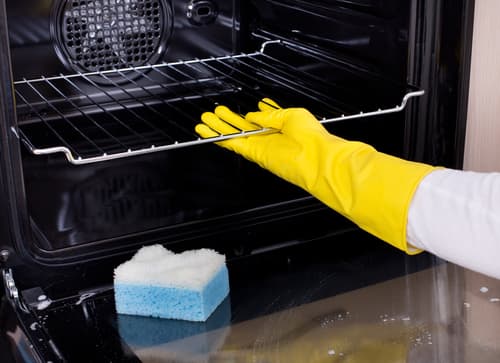 Can I use an oven cleaner on a self-cleaning oven